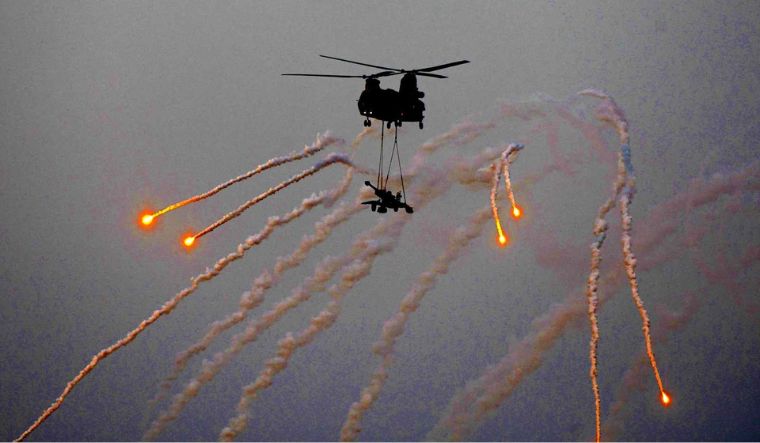 Indian Air Force's Chinook aircraft carries an artillery during a fire power demonstration at the Vayu Shakti 2024 at Pokhran Range in Jaisalmer district on February 17, 2024